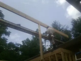 Carpenter setting a ridge beam over a new addition frame — Ice Dam Removal by Roofing Brothers in Congers