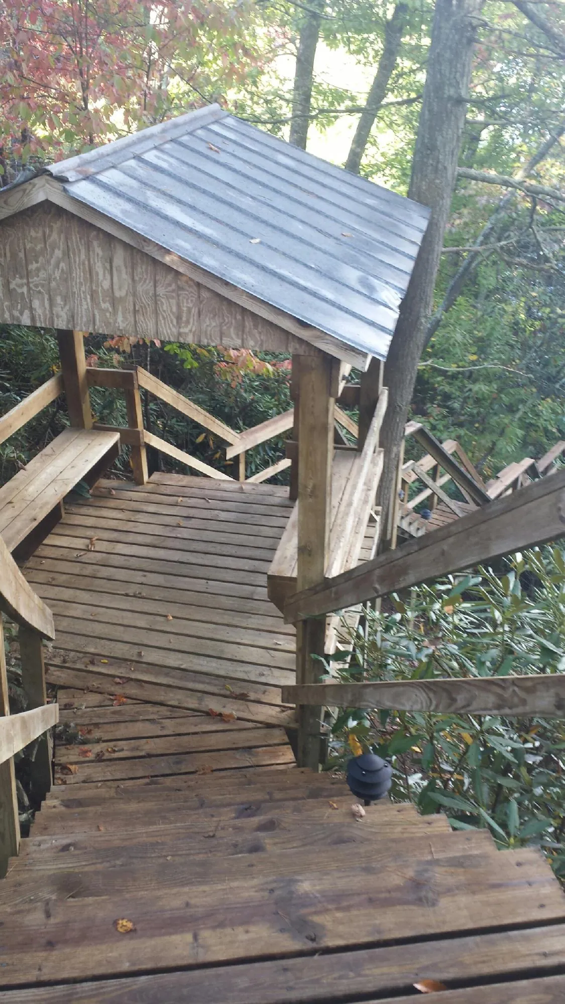 Metal roofed shelter over wooden steps on a wooded walkway — Skylight Repair & Installation work by our crew in Congers