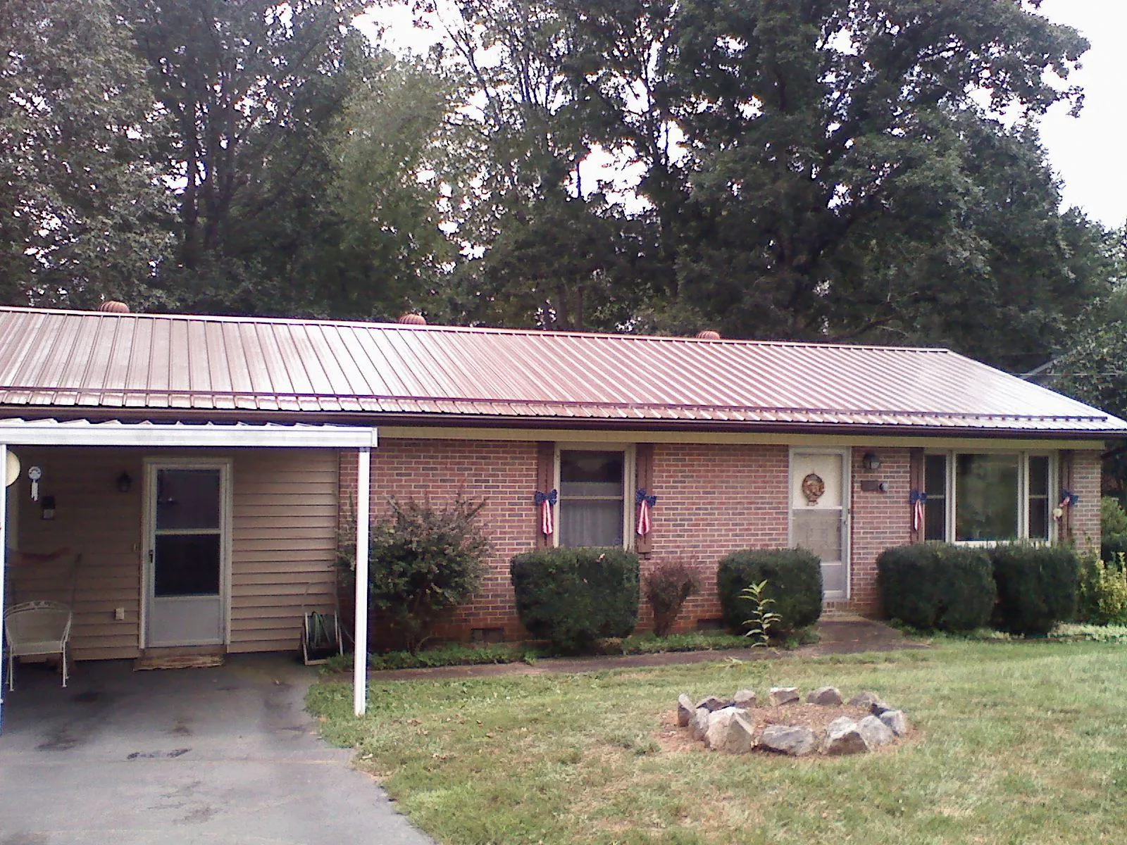 Bronze metal roof and carport on a brick ranch home — Roof Repair work by our crew in Congers